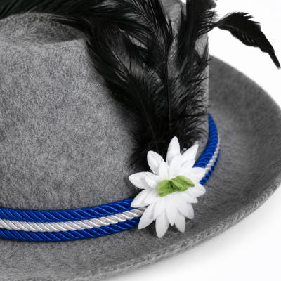 Detailaufnahme von Edelweißblüte, Feder und blau-weißer Kordel am Alpenhut