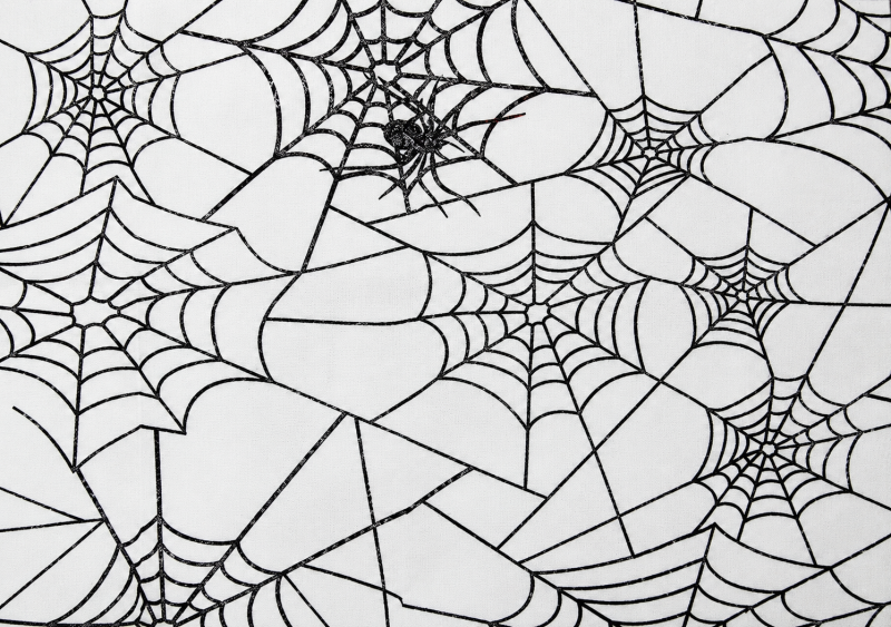 Detailansicht des Halloween Dekostoffs mit schwarzem Spinnennetz-Aufdruck