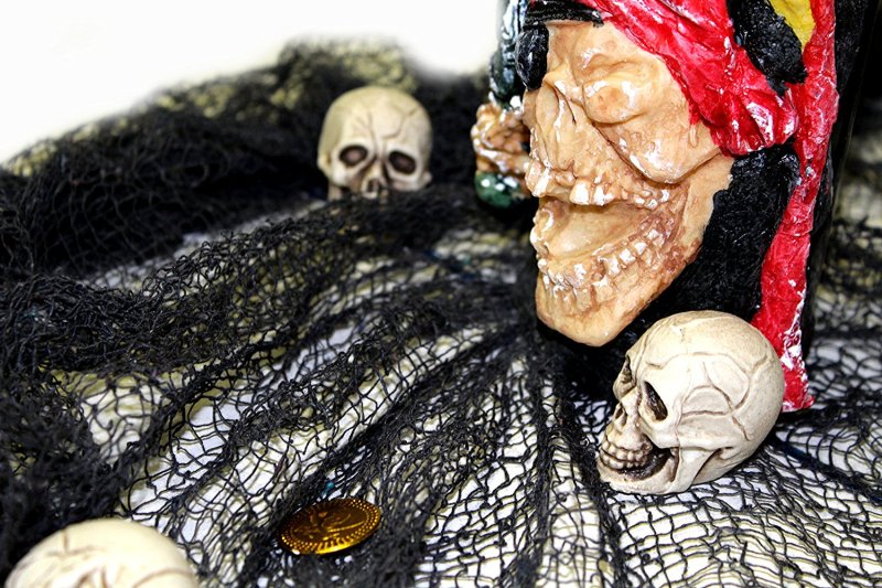 Schwarzer Gruselstoff mit Schädeln als Halloween Dekorationsbeispiel